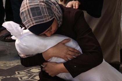 Une mère en larmes tient le corps de son enfant tué, symbolisant la douleur et le chagrin au milieu des conflits. En arrière-plan, une mention des envois d'armes de la France à Israël souligne la contradiction entre les discours de paix et les actions militaires.