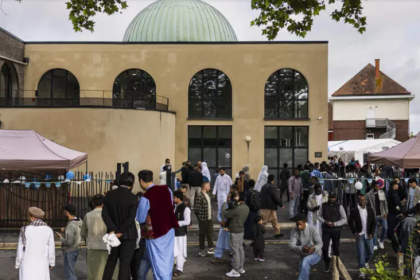Musulmans rassemblés devant une mosquée pour célébrer l’Aïd al-Adha, un moment de calme et de prière face à la réalité de menaces islamophobes en France.