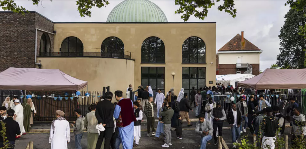 Musulmans rassemblés devant une mosquée pour célébrer l’Aïd al-Adha, un moment de calme et de prière face à la réalité de menaces islamophobes en France.